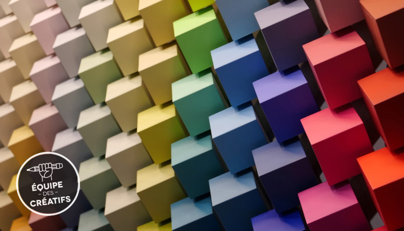 Mur composé de cubes en dégradé de couleurs allant du beige au rouge en passant par le vert et le bleu.