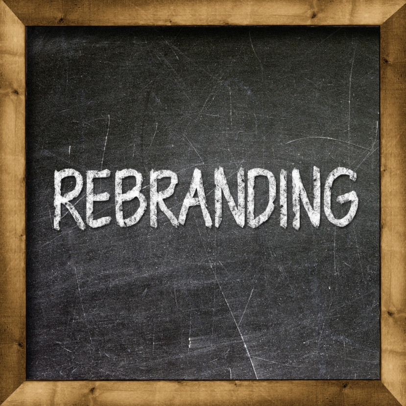 Mot « REBRANDING » écrit en lettres blanches sur un tableau noir encadré de bois.