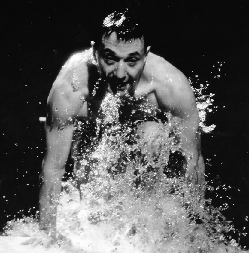 Régent Lacoursière sortant de l'eau avec éclaboussures visibles autour de son corps nu.