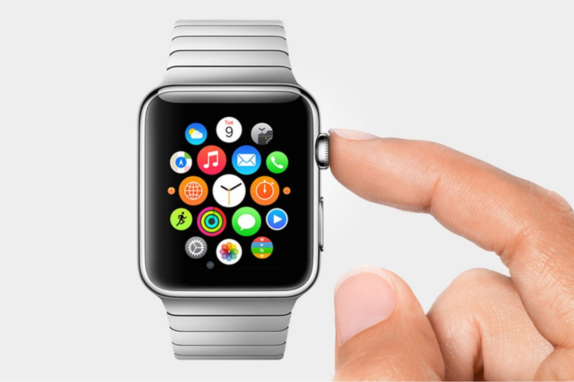 Montre Apple Watch avec écran d'applications colorées et bracelet métallique, doigt prêt à appuyer sur la couronne.