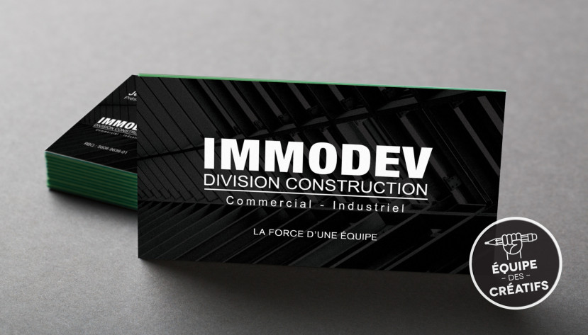 Carte d'affaires noire avec texte blanc pour IMMODEV Division Construction, secteur commercial et industriel.
