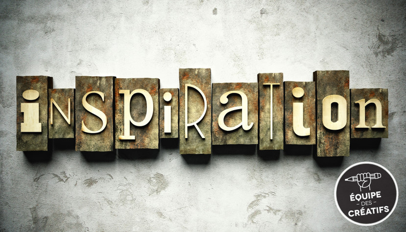 Mot "inspiration" en lettres vintage sur blocs de bois contre un mur gris texturé.