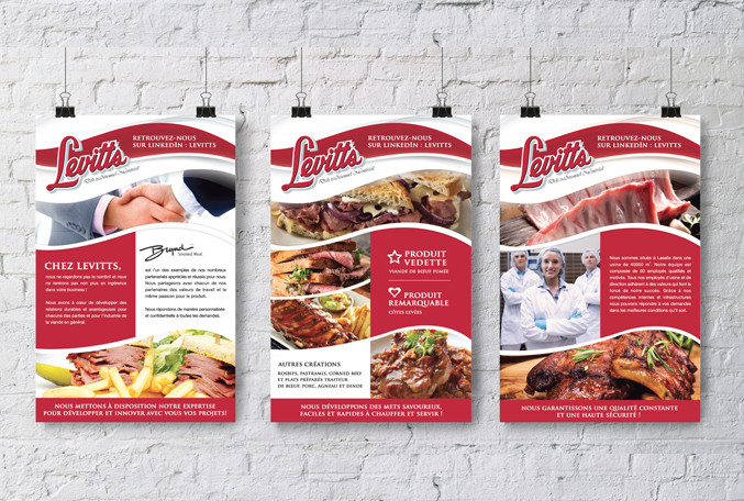 Trois affiches Levitts avec photos de sandwichs, viandes et équipe en uniforme sur mur de briques blanches.