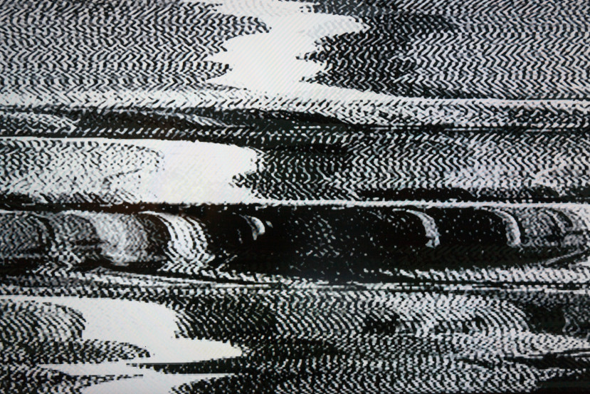 Écran noir et blanc avec interférences visuelles et distorsions statiques.
